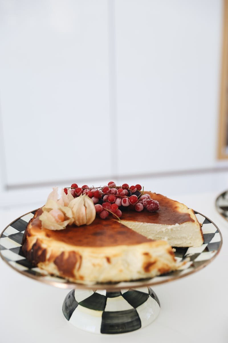 A creamy San Sebastian cheesecake garnished with fresh berries on a stylish checkered plate.