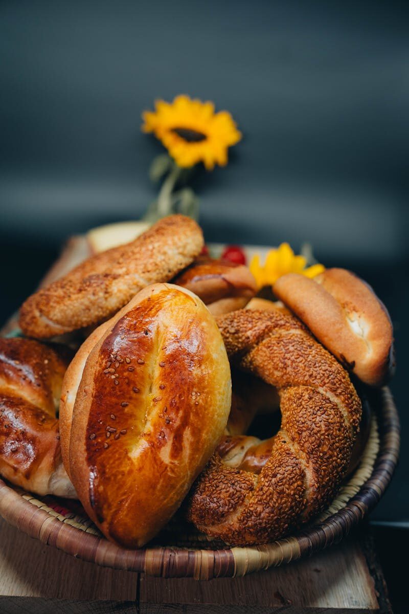 A selection of Turkish breads and pastries in a basket with sunflowers in the background.